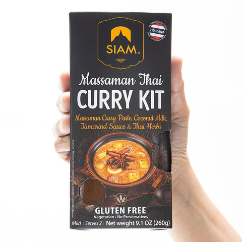 Siam Massaman Thai Curry Kit packaging held by a hand on a white background